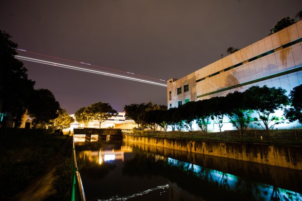 As we look out across the river an airplane flies by heading toward Changi Airport